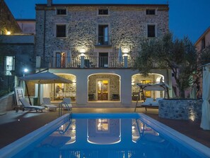 A stone building with a pool and outdoor seating. - Belvilla by OYO Villa Costiera (Vibonati)
