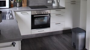 A compact kitchen with a microwave, oven, and sink.