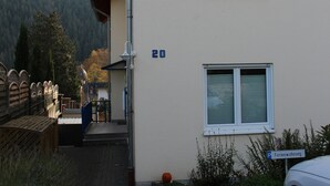 A building with a number 20 sign, a parking sign, and a car parked in front.