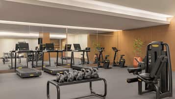 A gym with treadmills, elliptical machines, and free weights.