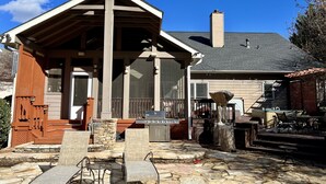A covered outdoor area with stone flooring, a grill, and outdoor furniture. - Perfect luxury home, close to social settings but far enough for peace. (Acworth)