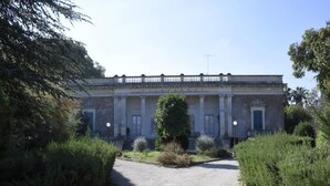 A building with a classical facade, a central entrance with steps, and a gravel pathway leading to it. - Villa Near Lecce With Garden and Beaches (Monteroni di Lecce)