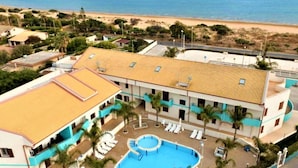 Ein Hotel mit Schwimmbad, Meerblick und mehreren Balkonen.