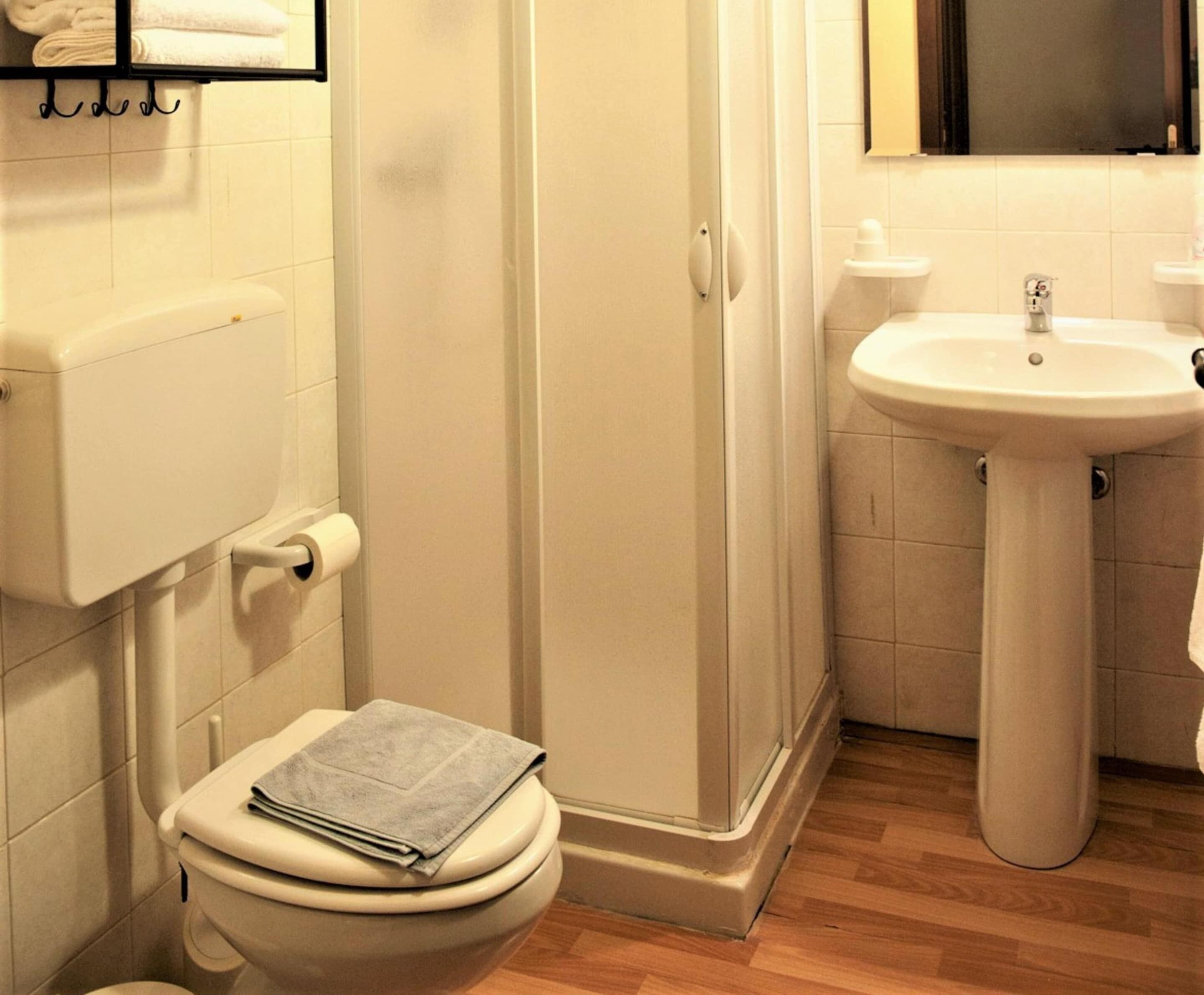 A bathroom with a toilet, a shower, and a sink.