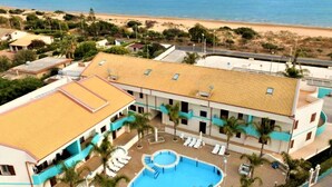 A hotel with a swimming pool, beach view, and multiple balconies. - Belvilla by Oyo Holiday Home in Ispica (Ispica)