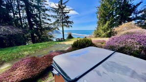 A hot tub in a garden with a view of the ocean and trees. - The Historic Requa Inn  (Klamath)