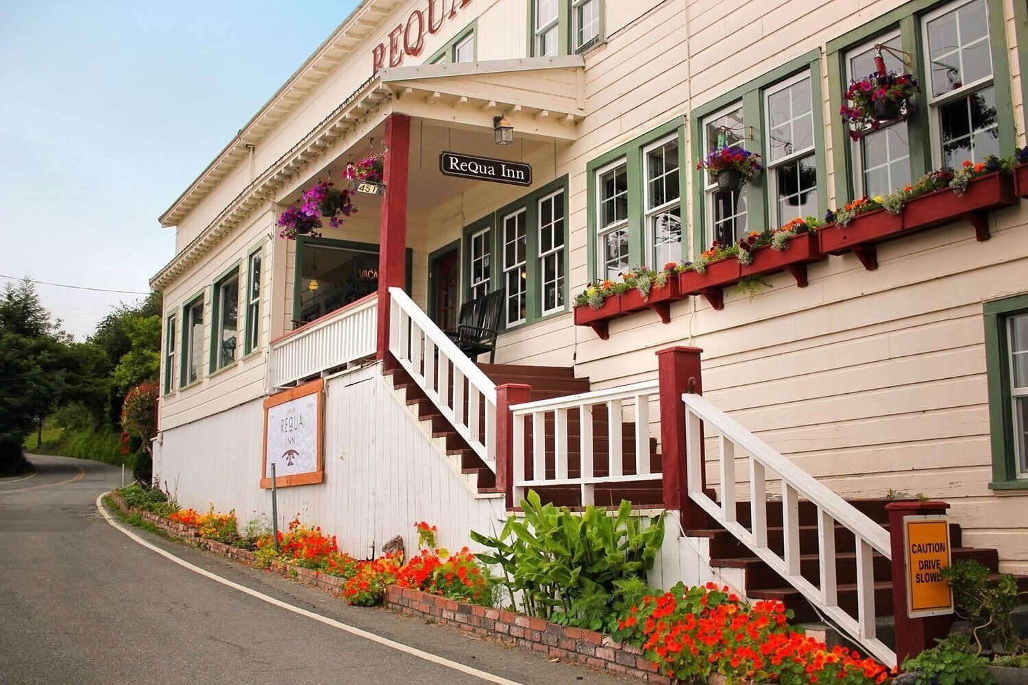 A building with a sign reading 'ReQua Inn' and a staircase leading to the entrance.