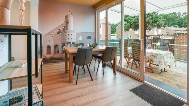 A dining area with a table and chairs, a wooden ceiling, and a view of the outside. - Stay With Garden, Limburg (Kerkrade)