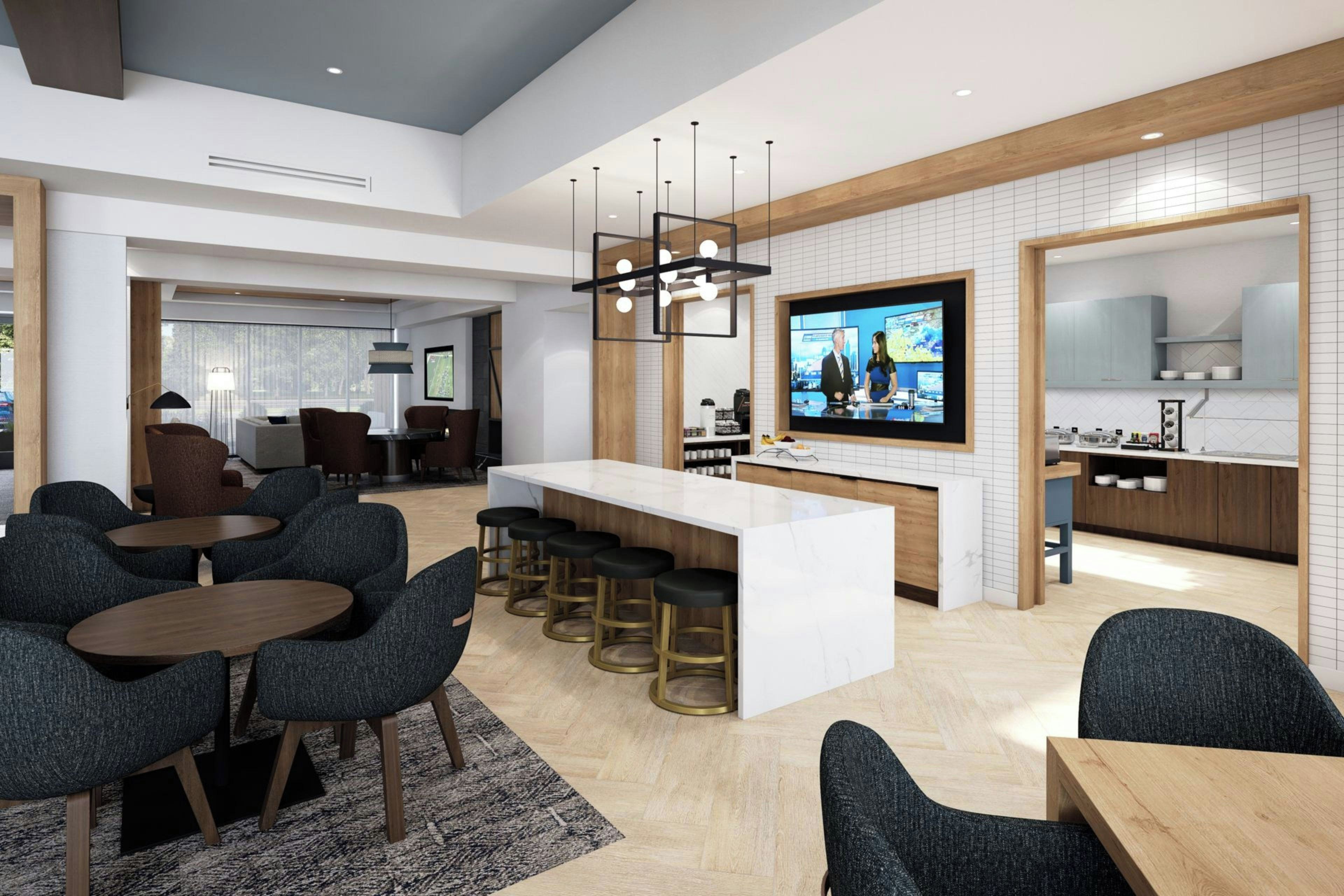 A modern hotel lobby with a bar area, seating, and a television screen.