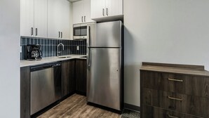 Een moderne keuken met roestvrijstalen apparatuur, witte kasten en een houten aanrecht.