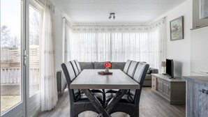 A dining area with a table and chairs, a television, and a cabinet. - Splendid Chalet in Bantega With a Jettty (Bantega)