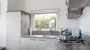 A modern kitchen with a window, stainless steel appliances, and a built-in oven. - Splendid Chalet in Bantega With a Jettty (Bantega)