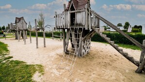 Une structure de jeu en bois, dotée d’une échelle de corde et d’un escalier.