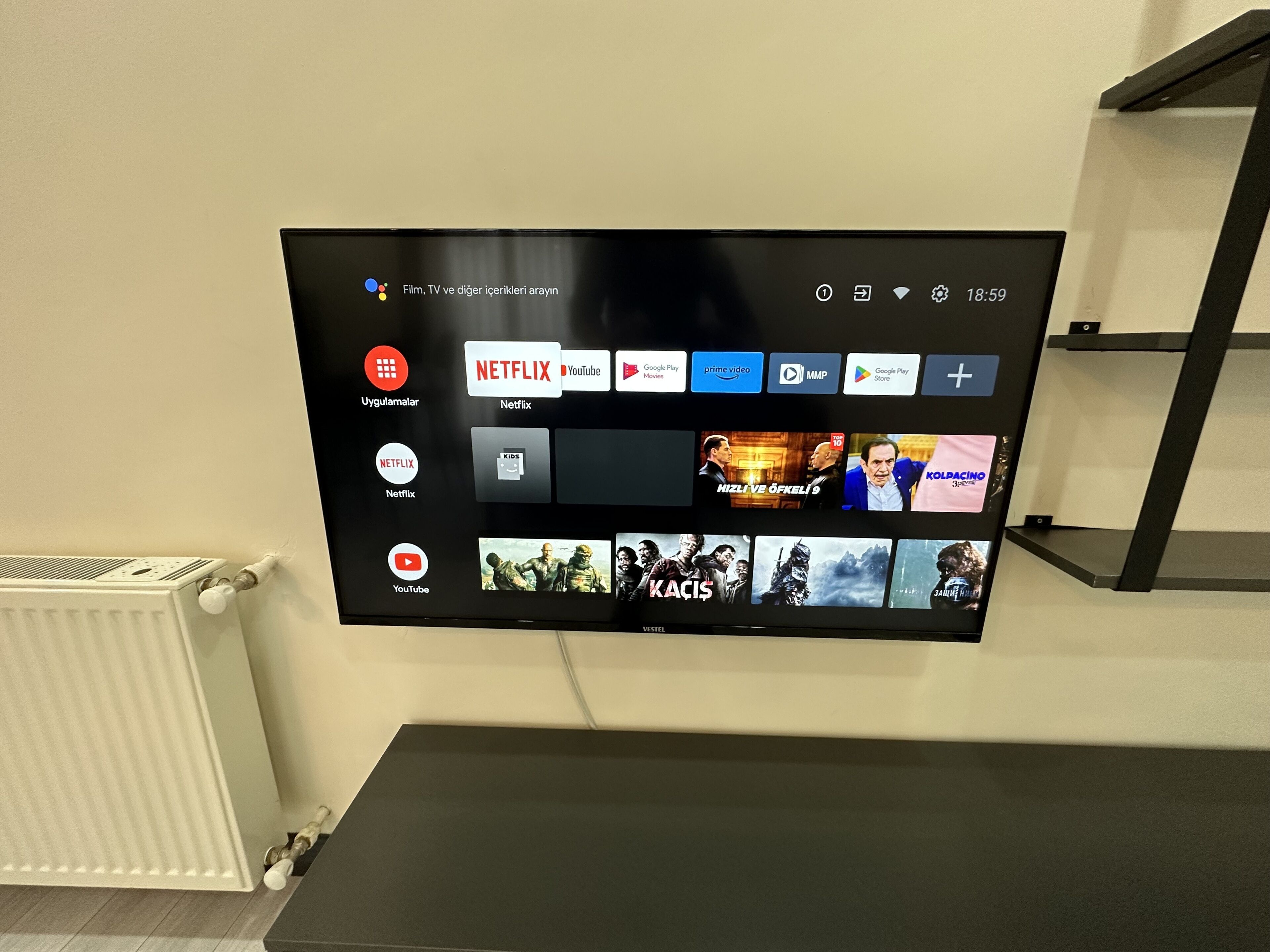 A flat-screen TV mounted on a wall displaying various streaming services.