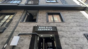 Fachada de un edificio con un letrero que dice "ROSE PLUS RESIDENCE".