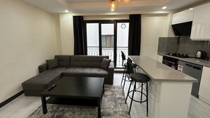 Un apartamento moderno con sala de estar, cocina y balcón.