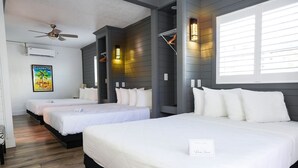 A hotel room with three beds, a ceiling fan, and a large window with blinds. - Devon Shores - Triple Queen (Clearwater)