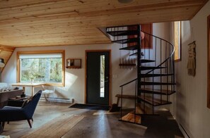 Een modern interieur met een spiltrap, een groot raam en een gezellige zithoek.