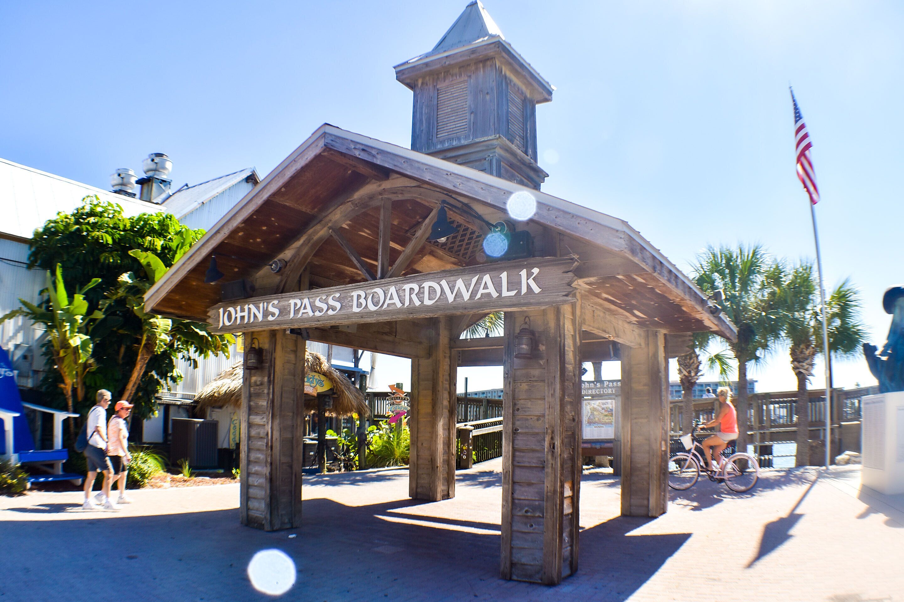 A wooden boardwalk structure with the sign "John's Pass Boardwalk".