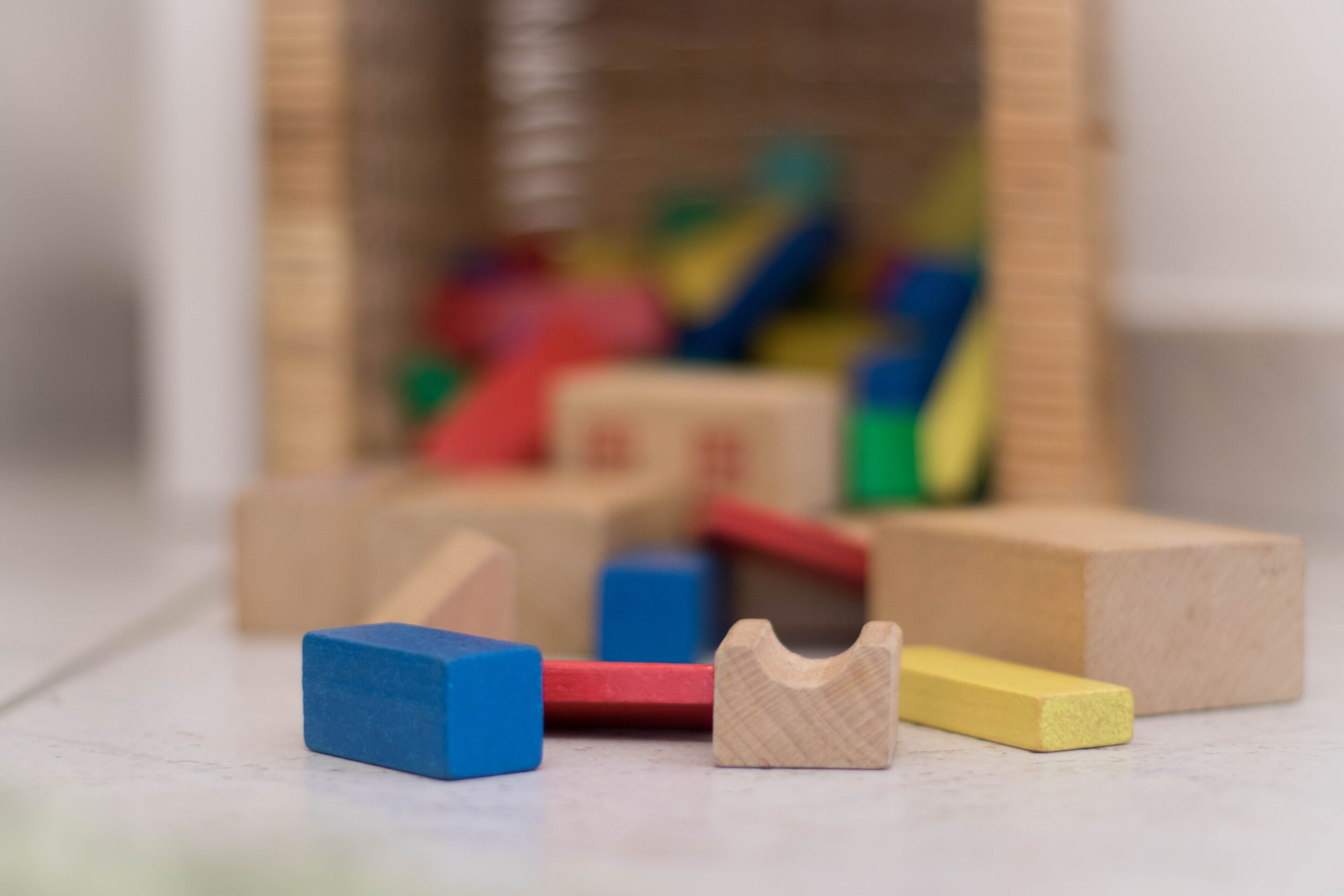 A close-up of colorful wooden blocks on a white surface.