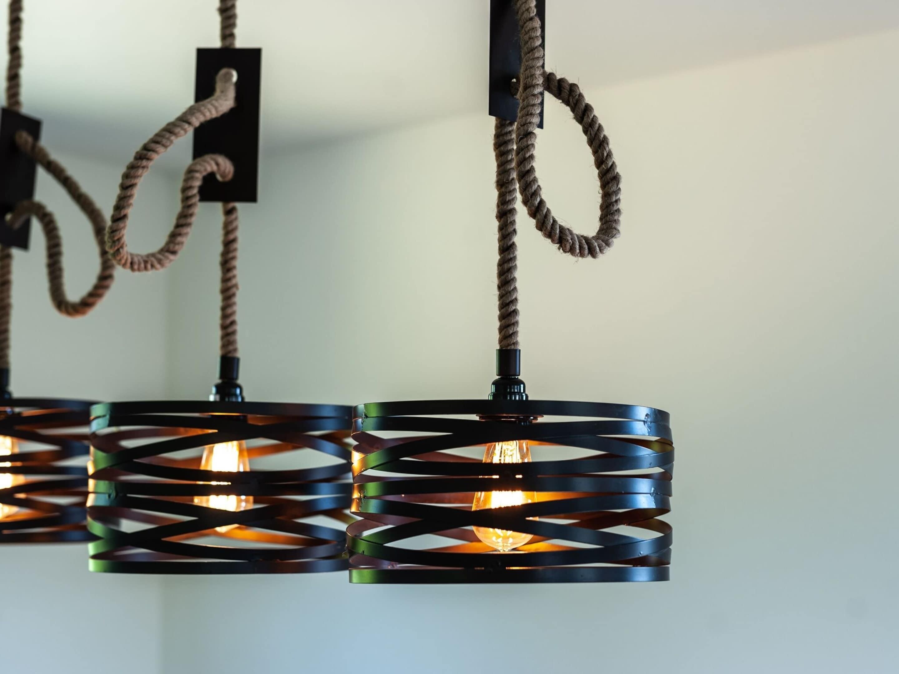 A series of pendant lights with a twisted rope design and a visible light bulb.
