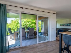 Een moderne woonkamer met een grote schuifglazen deur die leidt naar een terras.