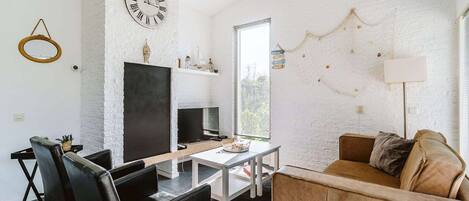 Una sala moderna con chimenea, un reloj y un rincón de descanso acogedor.
