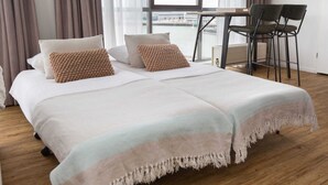 A hotel room with a large bed, a small table, and two chairs. - Holiday Home in Den Haag With Terrace (The Hague)