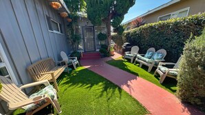 A backyard with a red pathway, a wooden bench, and two Adirondack chairs. - MB Gem 2 - 1.3Miles To Beach, Close To LAX & Park (Manhattan Beach)