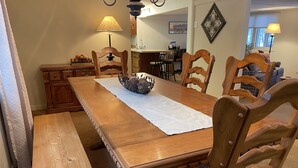A wooden dining table with a white table runner and a decorative basket. - Spacious Marquette Getaway  Trails Nearby  Perfect 4-Season Basecamp (Marquette)