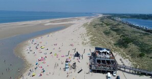 A beach with a pavilion and a stage for events, surrounded by sand and dunes. - 4-person Stay at Rustenpolder (Vrouwenpolder)