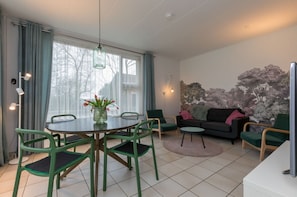A modern living room with a dining area, a sofa set, and a decorative wall. - 4-person Stay at Rustenpolder (Vrouwenpolder)