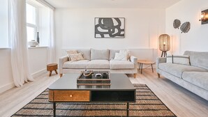 Ein modernes Wohnzimmer mit einem gestreiften Sofa, einem Couchtisch und einem Wanddekor.