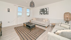 Ein modernes Wohnzimmer mit einer Couch, einem Couchtisch und einer Wanddekoration.