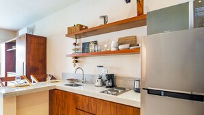 Een moderne keuken met houten kastjes, een roestvrijstalen koelkast en een inbouwoven.