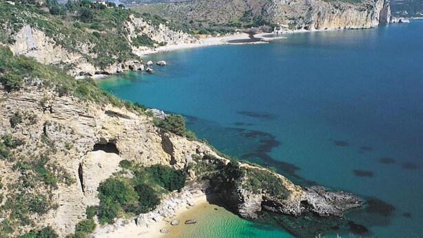 A coastal landscape with a rocky shoreline, clear turquoise waters, and a sandy beach. - Pet-friendly Getaway (Centola)