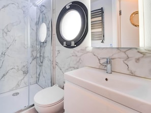 A bathroom with a marble backsplash, a toilet, a sink with a mirror, and a towel rack. - Modern Houseboat in Volendam With Shared Pool (Volendam)