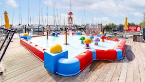 Ein Wasserspielplatz mit bunten Rutschen und einer Leuchtturm-Struktur.