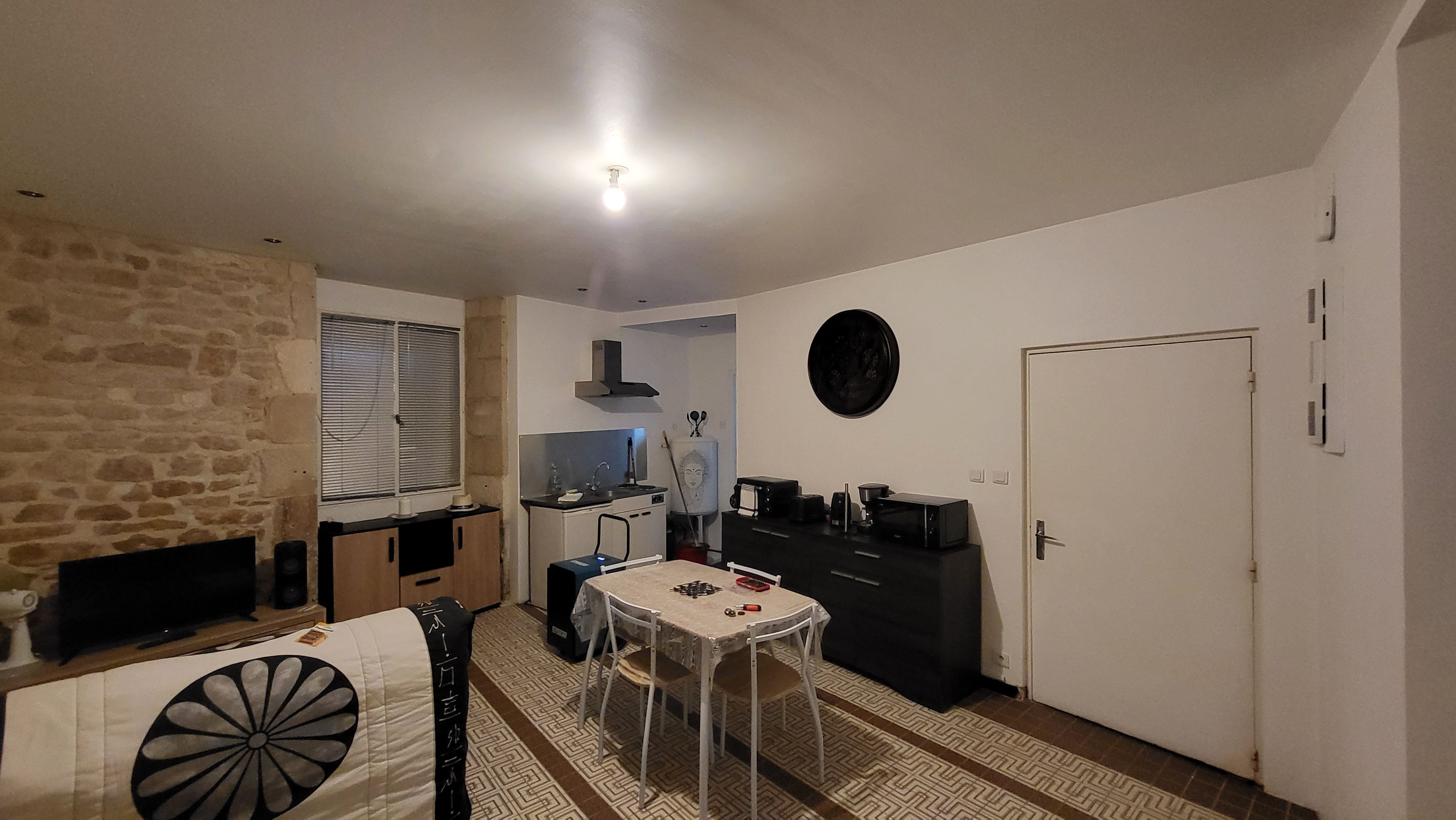 Un espacio habitable compacto con una mesa de comedor, área de cocina y una puerta.