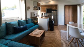 A compact living space with a sofa, coffee table, and a dining area. - Chalet in Oostkapelle Near Beach & Pool (Oostkapelle)