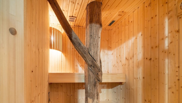 A wooden cabin interior with a wooden staircase, a bench, and a window. - Farmhouse in Staphorst With Sauna (Rouveen)