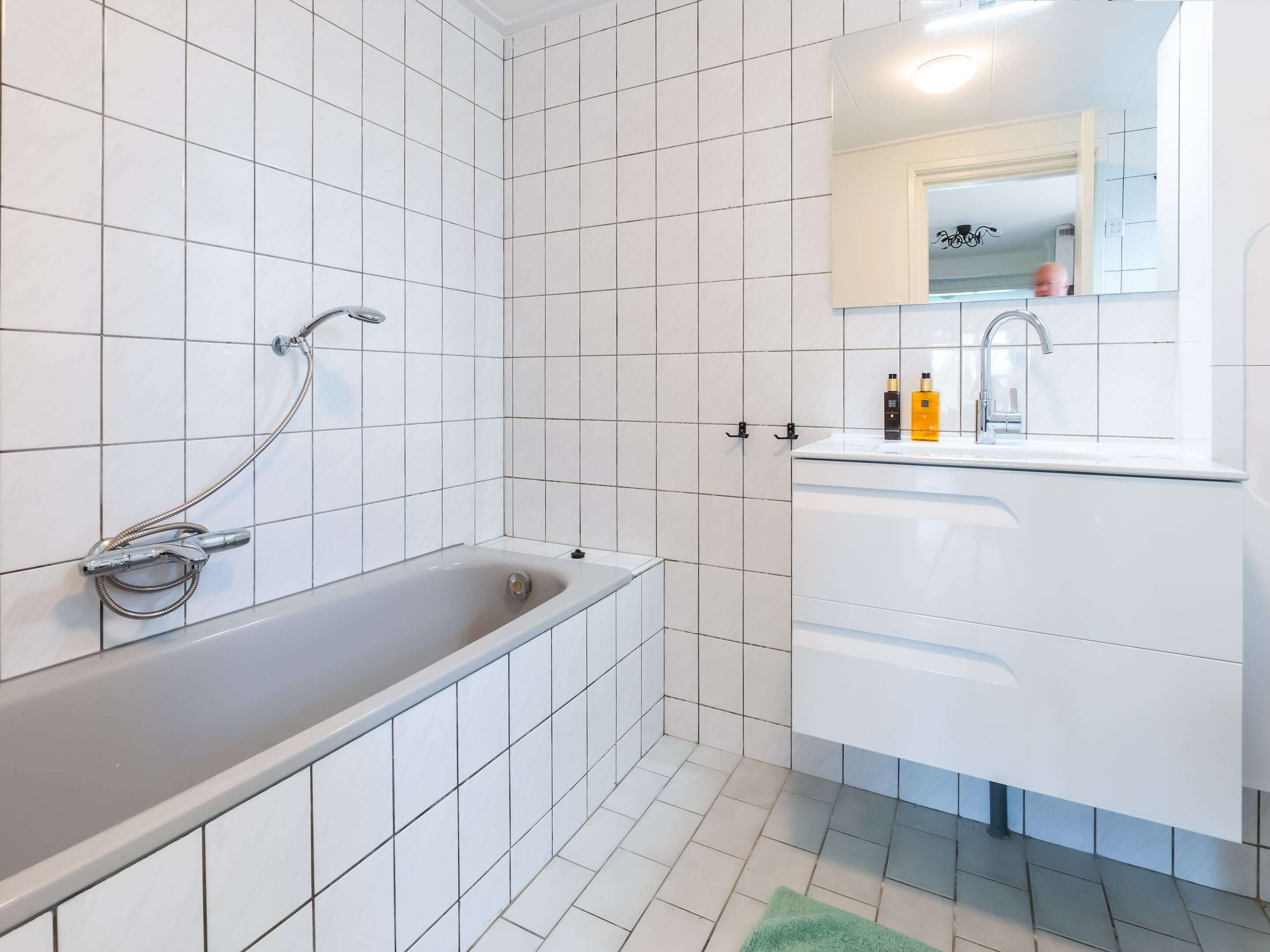 Un baño moderno con bañera, lavamanos y espejo.