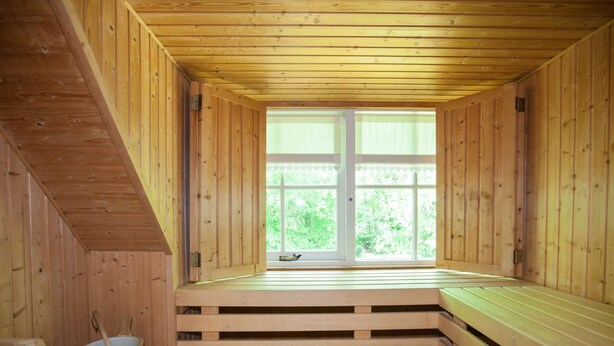 Una sauna de madera con bancos y una ventana.