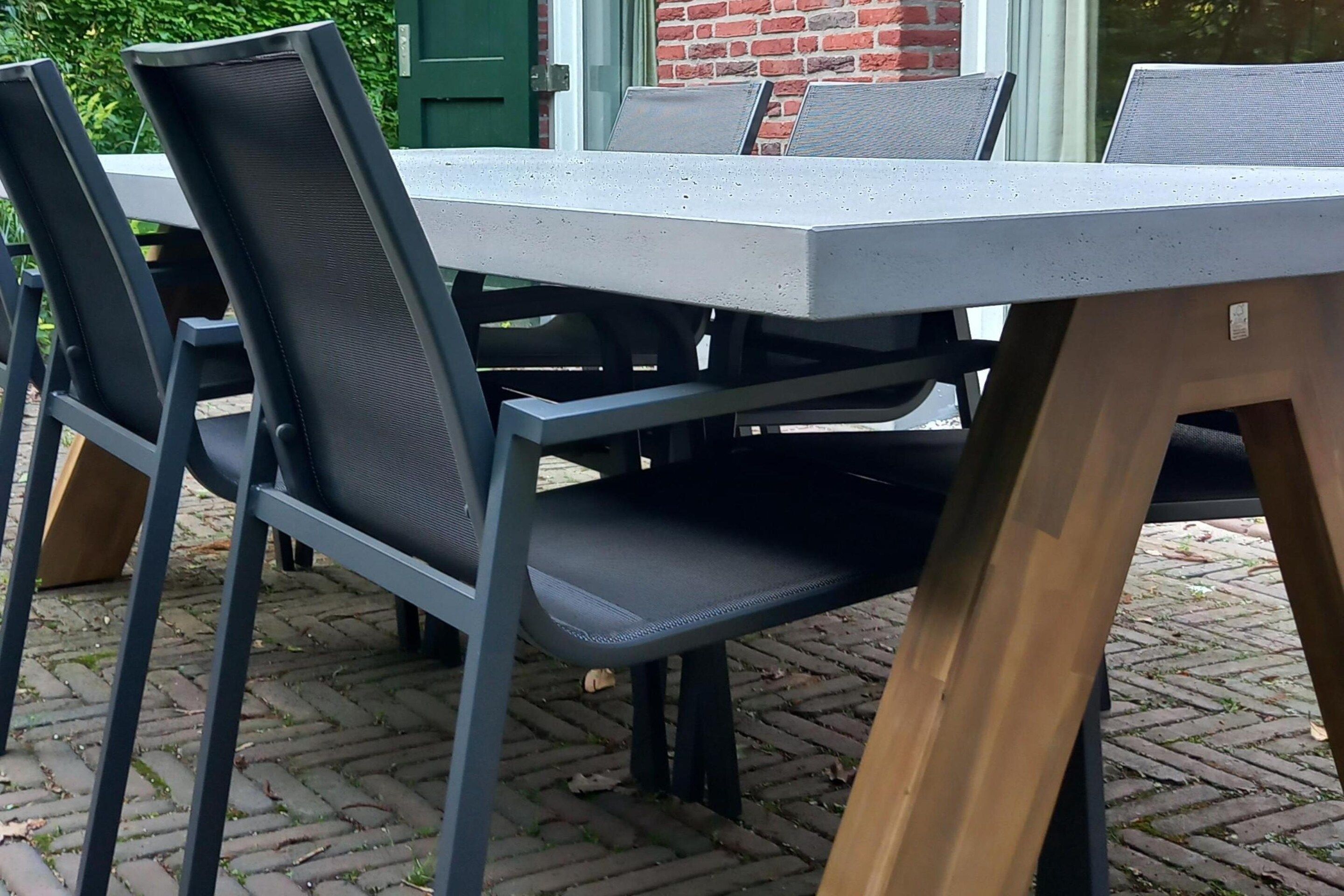 A table with chairs, a brick wall, and a green door in the background.