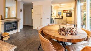 Un comedor con una mesa redonda de madera, sillas de cuero y un centro decorativo de metal.