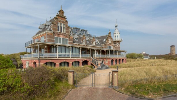 A large, historic house with multiple levels, a prominent tower, and a gated entrance. - Apartment Right in the Centre of Domburg (Domburg)