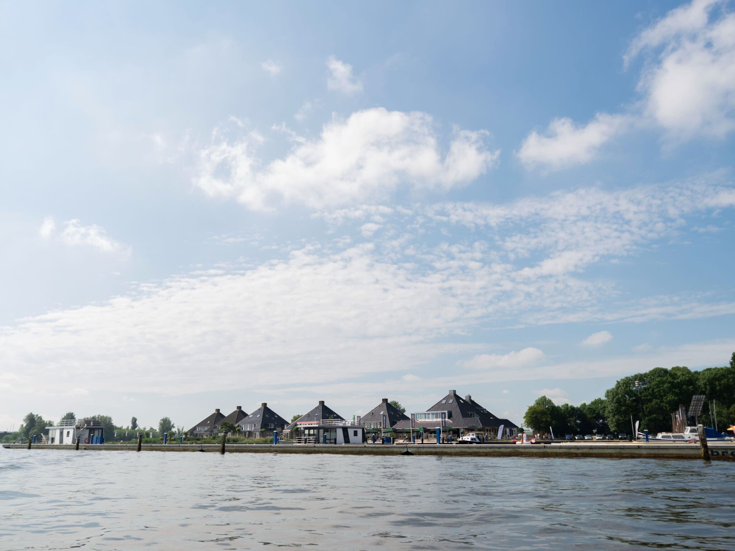A waterfront property with multiple houses, a dock, and a clear sky.