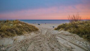 A beach path leading to the sea with footprints and sparse vegetation. - Hotel Balticpetite (Heringsdorf)