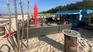 A beachside café with outdoor seating, a Coca-Cola vending machine, and a sign for 'DESPERADOS'. - Hotel Balticpetite (Heringsdorf)