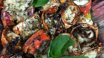 A tray of roasted crabs garnished with herbs.